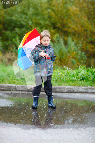 Image of Cute boy outdoors at rainy day