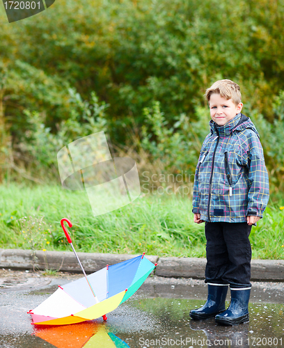 Image of Boy with umbrella in puddle