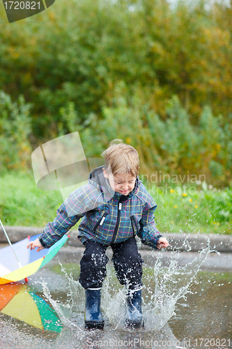 Image of Boy jumping in puddle