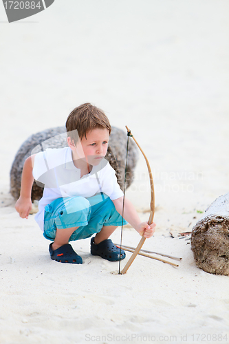 Image of Cute boy playing with bow and arrows