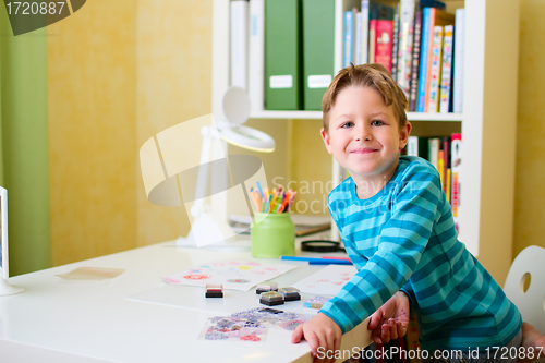 Image of Happy school boy doing homework