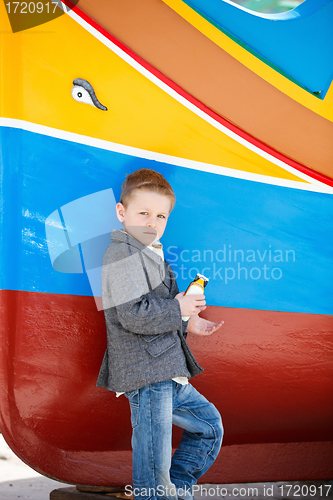 Image of Boy near colorful boat