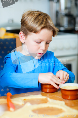 Image of Cute boy making cupcakes