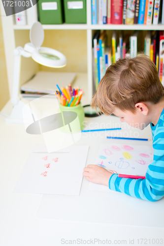 Image of Portrait of happy schoolboy at home