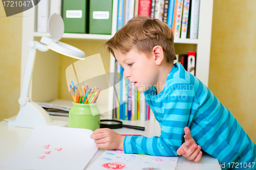 Image of School boy doing homework at home