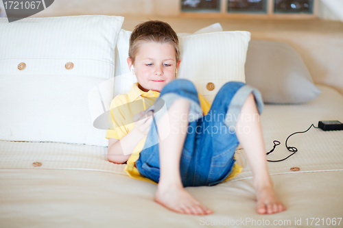 Image of Boy playing video games on portable device