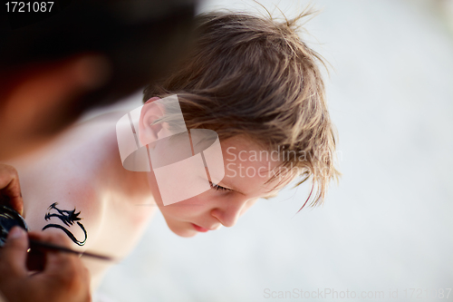 Image of Boy having henna tattoo