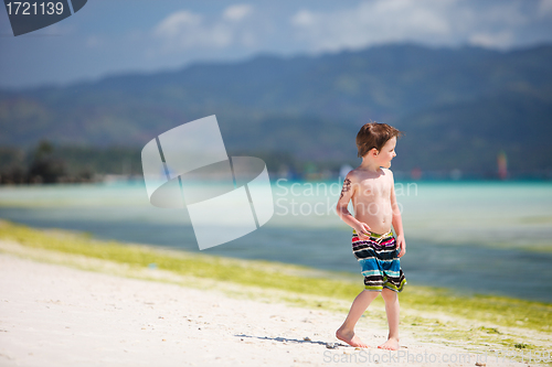 Image of Little boy standing by ocean shore