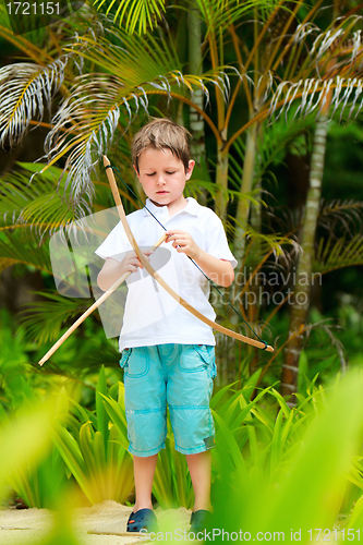 Image of Cute boy playing with bow and arrows