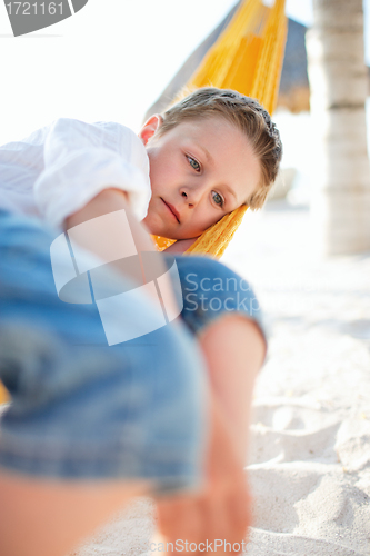 Image of Cute boy relaxing in hammock