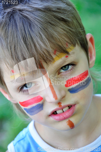 Image of football fan child with painting on his face 