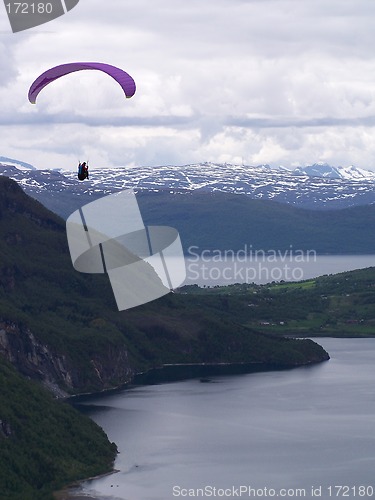 Image of Paraglider over water with mountains