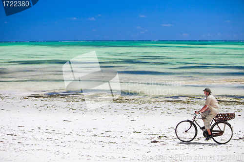 Image of Man biking at beach