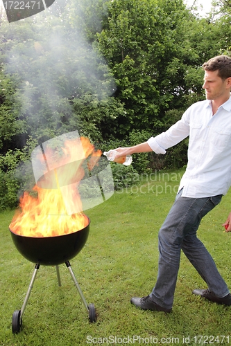 Image of BBQ with fire an young man