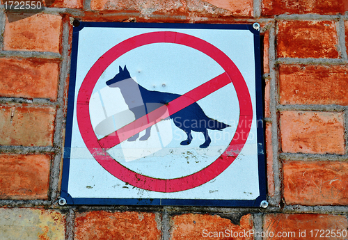 Image of Sign prohibiting walk out dogs in park on red brick house wall 
