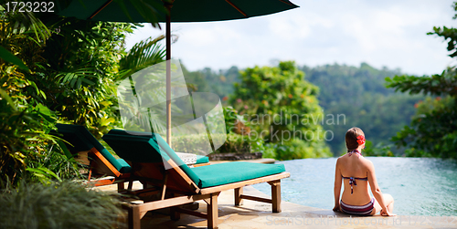 Image of Woman relaxing at swimming pool