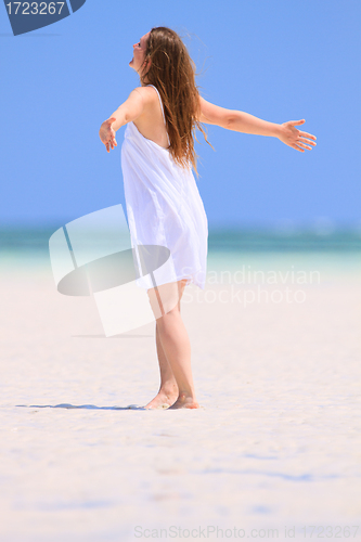 Image of Young woman dancing at beach