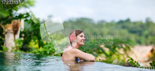 Image of Woman relaxing at swimming pool