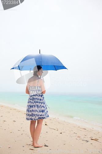 Image of Woman at beach under rain