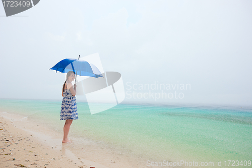 Image of Woman at beach under rain