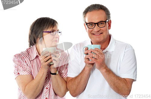 Image of Romantic senior couple holding coffee mugs