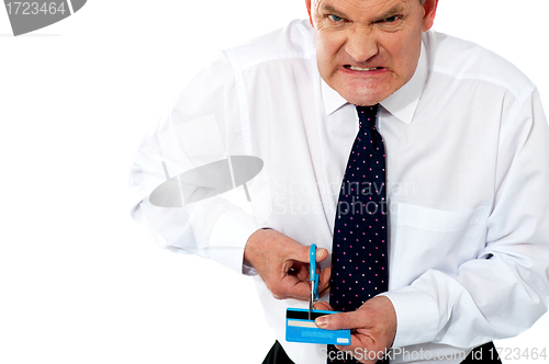 Image of Frustrated businessman cutting his credit card