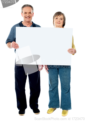 Image of Happy senior couple holding a white placard