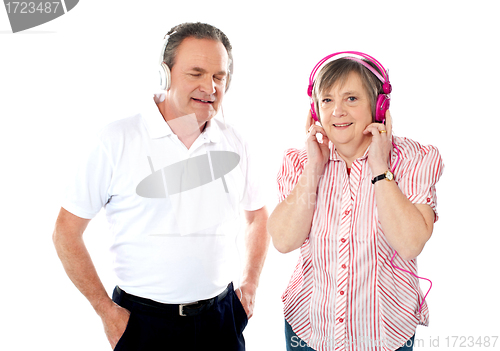 Image of Happy aged couple enjoying music together