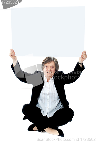 Image of Seated businesswoman holding blank whiteboard