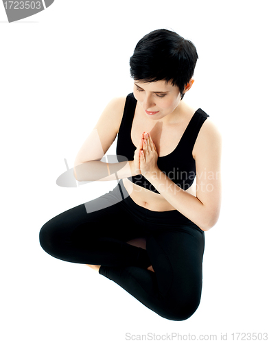 Image of Young woman practicing yoga in the lotus position