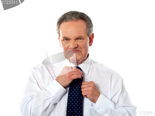 Image of Serious businessman adjusting his tie