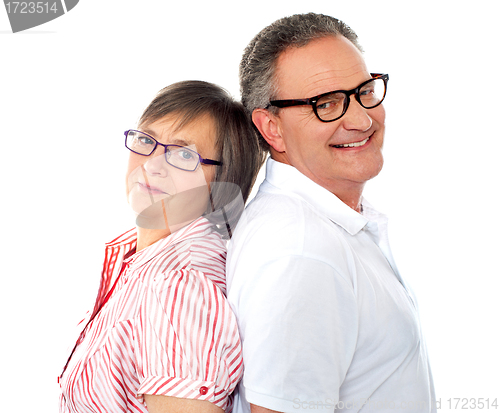 Image of Portrait of smiling aged couple posing back to back