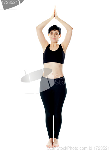 Image of Full-length view of fit woman doing yoga