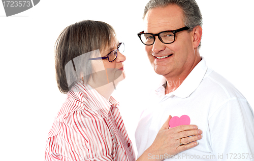 Image of Senior couple with pink heart isolated on white