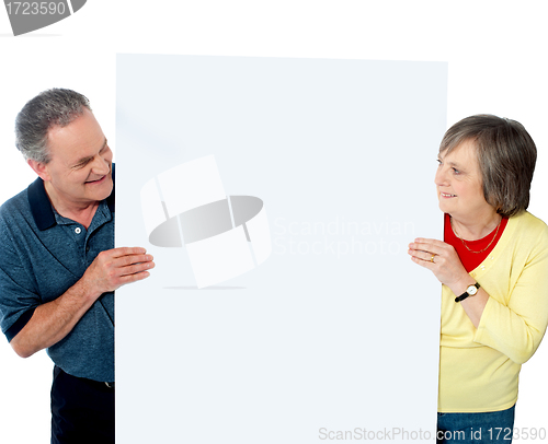 Image of Old age couple presenting banner together