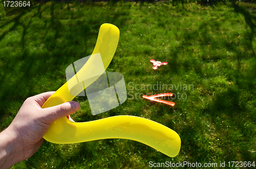 Image of Hand hold boomerang thrown flying toy play outside 