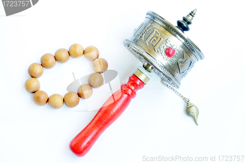 Image of Tibetan prayer wheel and beads on a white background