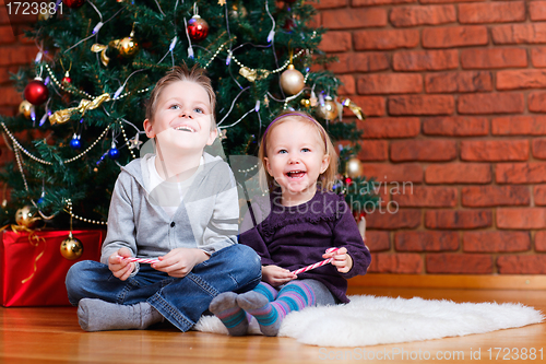 Image of Brother and sister near Christmas tree