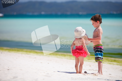 Image of Two adorable kids standing by ocean shore