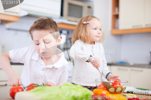 Image of Two little kids making salad