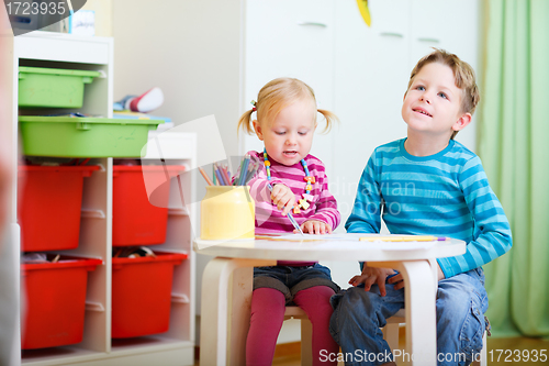 Image of Two kids drawing with coloring pencils