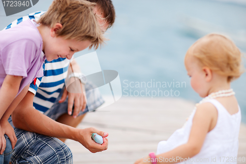 Image of Father showing his kids a fish.