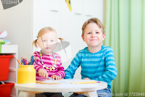 Image of Two kids drawing with coloring pencils