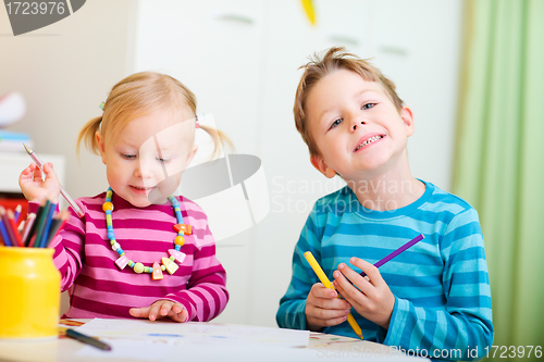 Image of Two kids drawing with coloring pencils