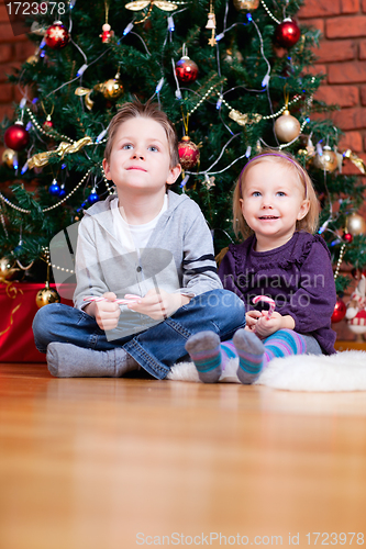 Image of Brother and sister near Christmas tree