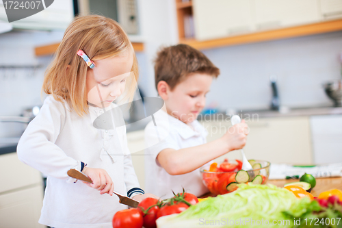 Image of Two little kids making salad