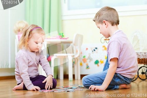 Image of Brother and sister solving puzzle