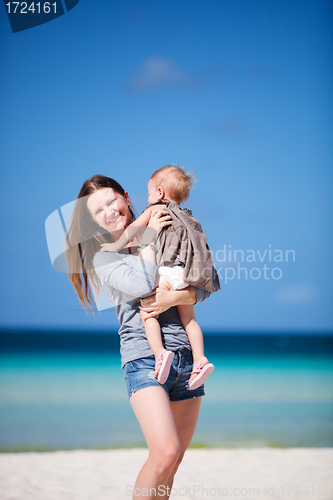 Image of Mother with daughter walking on beach