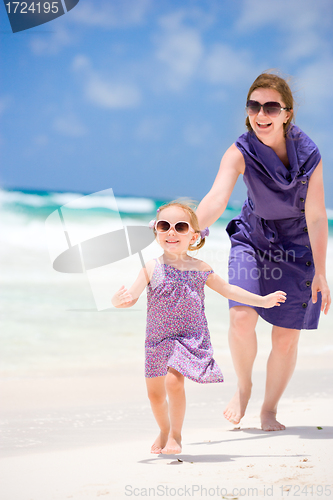 Image of Mother and daughter running at beach