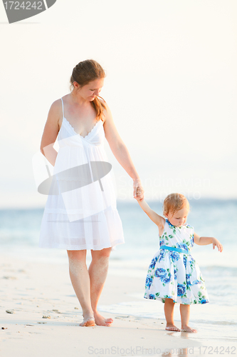 Image of Mother and daughter on tropical beach at sunset